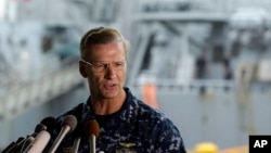 Vice Adm. Joseph Aucoin, commander of the U.S. 7th Fleet, speaks during a press conference, with the damaged USS Fitzgerald in the background at the U.S. Naval base in Yokosuka, southwest of Tokyo, June 18, 2017.