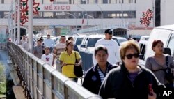 FILE - Pedestrians cross the Gateway to the Americas International Bridge from Mexico into the U.S. in Laredo, Texas, Dec. 3, 2007.