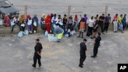 Migrants wait to board a ferry boat from the port of Lampedusa, for Sicily, southern Italy, where they will be sent to other camps based on their legal status, Oct. 7, 2013.