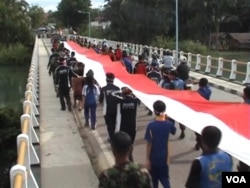 Bendera merah putih sepanjang 100 meter diarak melintasi 27 desa menuju ibukota Poso dalam peringatan Hari Pahlawan (10/11).