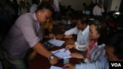 Opposition supporters thumbprint a petition to King Norodom Sihamoni at the Cambodia National Rescue Party's headquarters in Phnom Penh, Thursday, June 2, 2016.