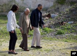 FILE - Then-U.S. President Barack Obama, right, and first lady Michelle Obama, left, tour Robben Island with Ahmed Kathrada, June 30, 2013, in South Africa.