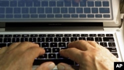 FILE - Hands type on a computer keyboard in Los Angeles, Feb. 27, 2013.