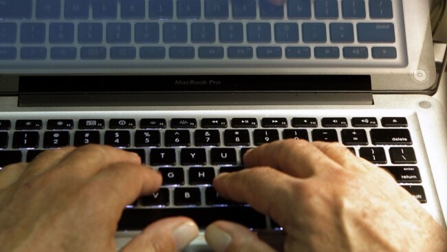 FILE - Hands type on a computer keyboard in Los Angeles, Feb. 27, 2013.