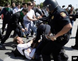 Police officers take a man into custody who was protesting against Republican presidential candidate Donald Trump outside the Hyatt Regency hotel during the California Republican Party 2016 Convention in Burlingame, Calif., April 29, 2016.