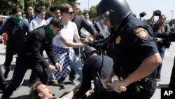 Police officers take a man into custody who was protesting against Republican presidential candidate Donald Trump outside the Hyatt Regency hotel during the California Republican Party 2016 Convention in Burlingame, Calif., April 29, 2016.