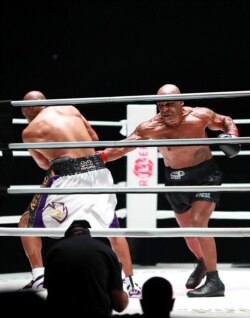 Mike Tyson (kanan) melakukan pukulan di ronde keempat melawan Roy Jones Jr., dalam pertandingan tinju Mike Tyson vs Roy Jones Jr. di Staples Center, Los Angeles, California, 28 November 2020. (Foto oleh Joe Scarnici / Getty Images Amerika Utara / AFP)