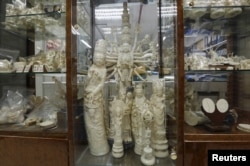 FILE - Products from elephant ivory are displayed on the centre column of a shelf inside a carving and jewellery factory in Hong Kong, Oct. 23, 2015.