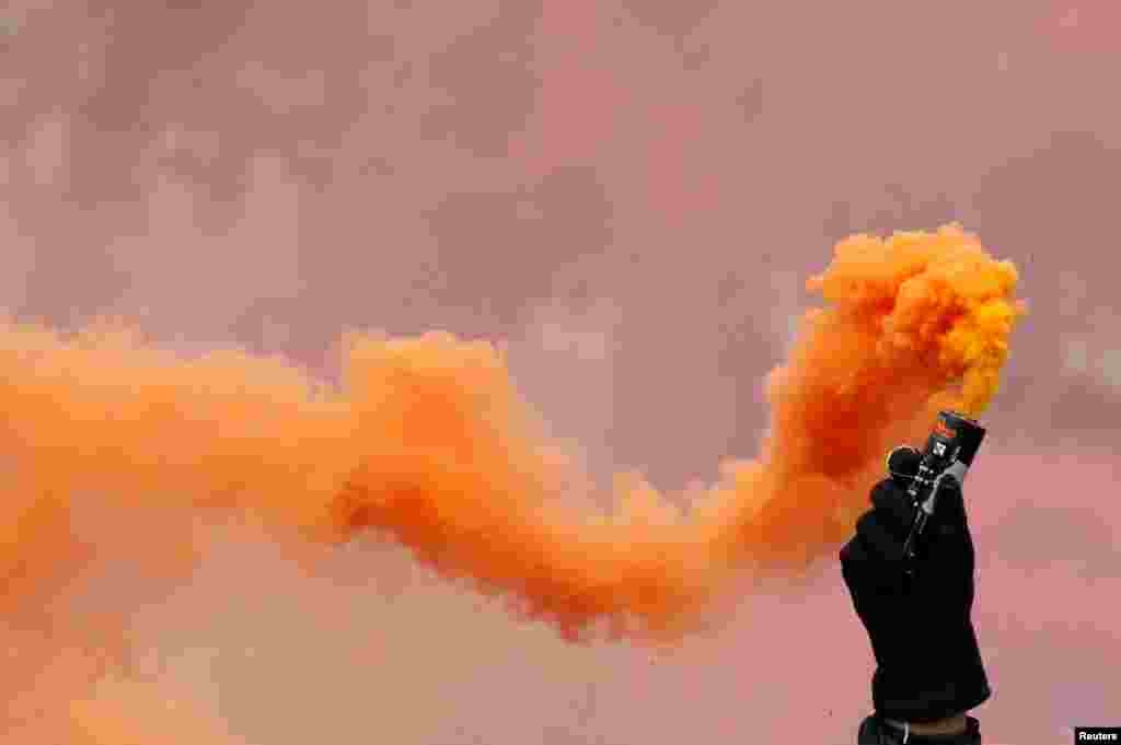 A protester holds a smoke safety flare during the May Day labour union march in Paris, France, May 1, 2018.