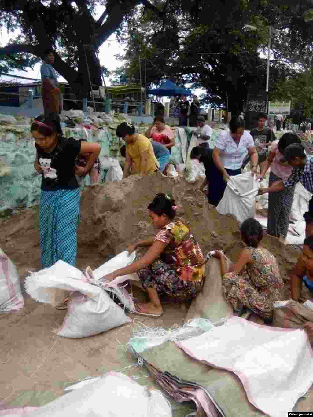 မံုရြာၿမိဳ႕မွာ ေရတားတမံေတြကို ကိုယ္ထူကိုယ္ထ တက္ညီလက္ညီ ပါဝင္လုပ္အားေပးေနတဲ့ မံုရြာၿမိဳ႕သူၿမိဳ႕သားမ်ား။ (ၾသဂုတ္လ ၂၊ ၂၀၁၅/ ဓာတ္ပံု မံုရြာသား)