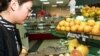 Seorang konsumen China mengamati buah limau gedang yang diimpor dari Florida, AS pada sebuah supermarket di Beijing (foto: ilustrasi). 