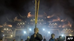 农历正月初一(2018年2月16日)，人们在上海龙华寺点香祈福。