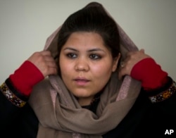 FILE - Afghan women’s rights activist Wazhma Frogh adjusts her scarf during an interview in her office in Kabul, Afghanistan, March 5, 2014. A gender and development specialist and human rights activist, Frogh says for Afghan women, the successes are fragile.