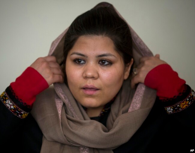 FILE - Afghan women’s rights activist Wazhma Frogh adjusts her scarf during an interview in her office in Kabul, Afghanistan, March 5, 2014. A gender and development specialist and human rights activist, Frogh says for Afghan women, the successes are fragile.