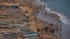 Quelques personnes sur une plage à proximité de canots de pêche à Dakar, au Sénégal, le 21 juin 2013. 