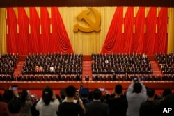 FILE - Journalists take pictures of Chinese President Xi Jinping, front row center, and other Communist Party officials at Party Congress at the Great Hall of the People in Beijing, Oct. 24, 2017. Journalists in China are educated to serve the party, says a journalism professor of at China's Guangzhou University.