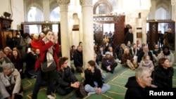 Visitors watch members of the Muslim community praying in the Paris Grand Mosque during an open day weekend for mosques in France, Jan. 10, 2016. 