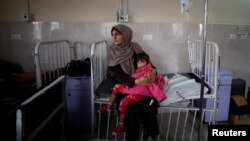 A sick Palestinian girl is held by her mother inside a room at the Durra hospital in Gaza City, Feb. 6, 2018. (REUTERS/Mohammed Salem)