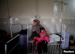 A sick Palestinian girl is held by her mother inside a room at the Durra hospital in Gaza City, Feb. 6, 2018.