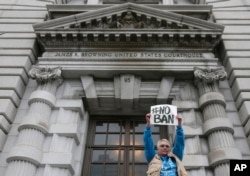 FILE - Karen Shore holds up a sign outside of the 9th U.S. Circuit Court of Appeals in San Francisco, Feb. 7, 2017.