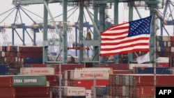 FILE - Chinese shipping containers are stored beside a U.S. flag after they were unloaded at the Port of Los Angeles in Long Beach, California, on May 14, 2019. 