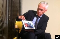 Univision’s Jorge Ramos shows a video he says his crew shot the previous day showing Venezuelan youth picking food scraps out of the back of a garbage truck in Caracas, during an interview at a hotel in Caracas, Venezuela, Feb. 25, 2019.
