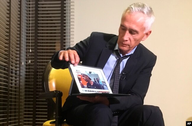 Univision’s Jorge Ramos shows a video he says his crew shot the previous day showing Venezuelan youth picking food scraps out of the back of a garbage truck in Caracas, during an interview at a hotel in Caracas, Venezuela, Feb. 25, 2019.