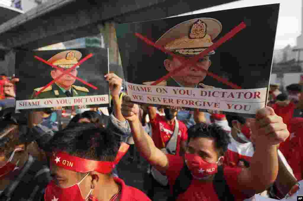 Myanmar citizens living in Thailand, hold pictures of military Commander-in-Chief Senior Gen. Min Aung Hlaing during a protest in front of the Myanmar Embassy, in Bangkok, Thailand.