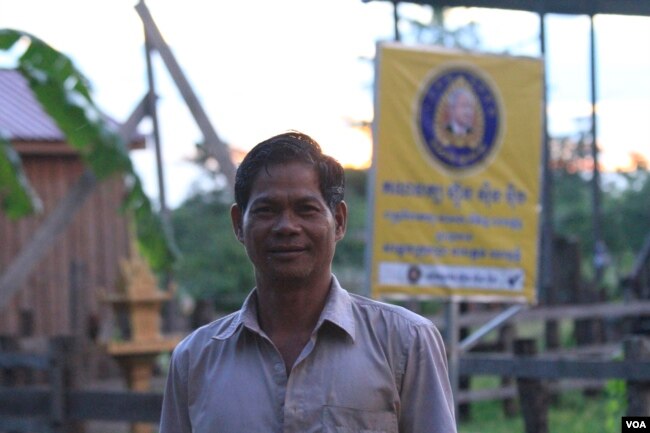 លោក ឡុង សុផាត អាយុ​៥០​ឆ្នាំ ជំទប់ទី​២​នៃ​ឃុំអូររៃ មក​ពីគណបក្ស​ហ្វ៊ុនស៊ិនប៉ិច ដែល​ទើប​តែ​ជាប់​នៅ​ក្នុង​ការ​បោះឆ្នោត​ក្រុមប្រឹក្សា​ឃុំ​សង្កាត់​កាល​ពីខែមិថុនា ឆ្នាំ២០១៧ ឈរ​នៅ​ខាងមុខ​ផ្ទះ​របស់​លោក កាល​ពី​ថ្ងៃ​ទី​១៩ ខែតុលា ឆ្នាំ២០១៧។ (ស៊ុន ណារិន/VOA)