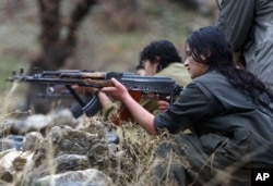 FILE - A member of the Free Life Party, or PJAK, trains on a weapon at the group's camp in the Qandil mountains in northern Iraq.