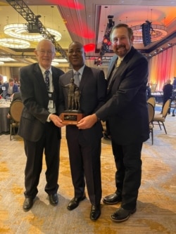 Mateus Mutemba (centro), Charles Duke Jr (esquerda, astronauta da Missão Apolo 16), e Rob Keck (direita, anterior vencedor do prémio)