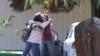 14일 총기난사 사건이 발생한 미국 캘리포니아주 란초 테하마 초등학교에서 두 여성이 포옹하며 서로를 위로하고
있다.