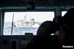 Kapal penjaga pantai China terlihat dari kapal TNI Angkatan Laut saat melakukan patroli di perairan Zona Ekonomi Eksklusif Indonesia di utara Pulau Natuna, 11 Januari 2020. (Foto: Antara/M Risyal Hidayat via REUTERS)