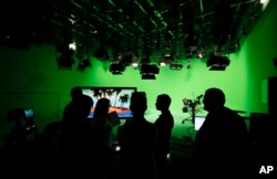 FILE - Employees of Russia's RT television channel are seen in a studio at the company's headquarters in Moscow, Russia, June 11, 2013.