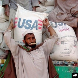 An Afghan man helps unload a shipment of US aid (file photo)