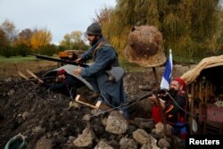 History enthusiasts, members of French association Tempus Fugit, dressed in World War I French military outfits, re-enact daily life of soldiers during trench warfare, in Ecourt-Saint-Quentin, France, Nov. 9, 2018, ahead of the centennial commemoration of the World War I Armistice Day.