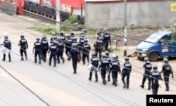 FILE - A still image taken from a video shows riot police walkin along a street in the English-speaking city of Buea, Cameroon, Oct. 1, 2017.