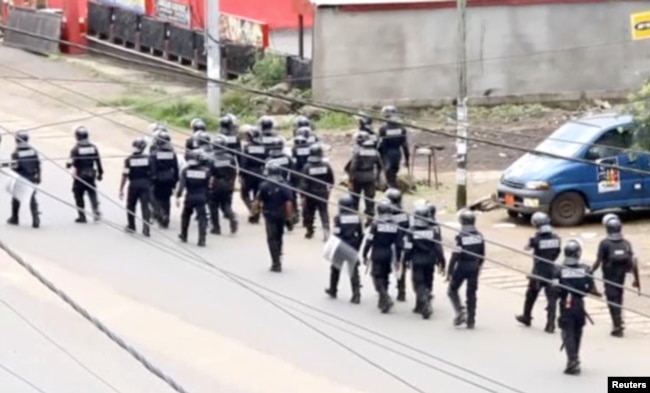 FILE - A still image taken from a video shows riot police walkin along a street in the English-speaking city of Buea, Cameroon, Oct. 1, 2017.