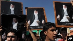 Supporters of the slain former Afghan president Burhanuddin Rabbani shout slogans and hold up his portrait during a protest against the Taliban and Pakistan in Kabul, September 27, 2011.