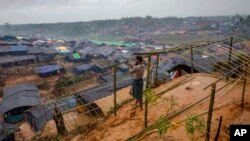 FILE - A Rohingya Muslim man, who crossed over from Myanmar into Bangladesh, builds a shelter for his family in Taiy Khali refugee camp, Bangladesh, Sept. 20, 2017. More than 500,000 Rohingyas poured across the border in late August to escape attacks in Myanmar.