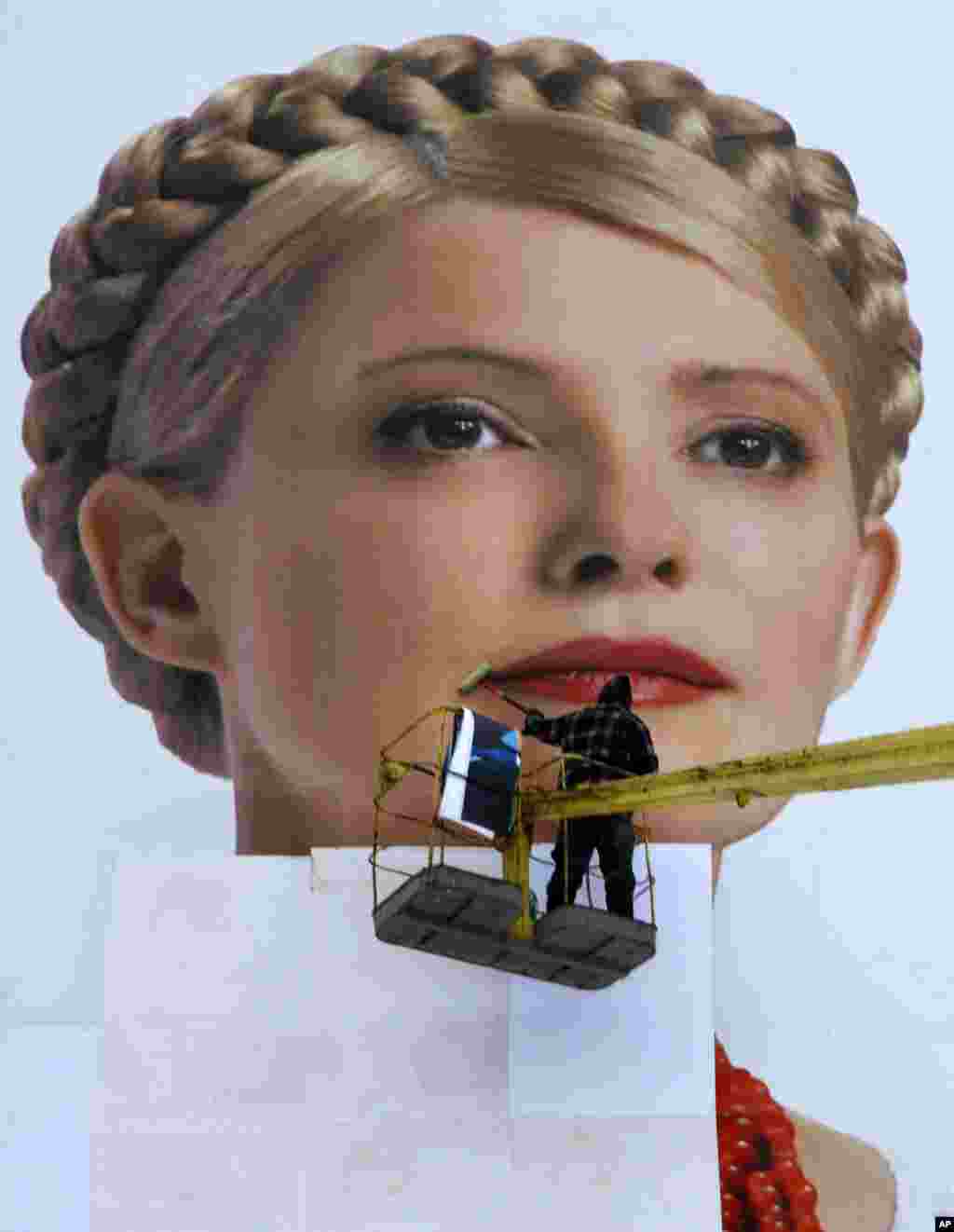 A worker pastes up a huge poster of Ukraine's then Prime Minister and Presidential candidate Yulia Tymoshenko, during a campaign in Kyiv, Ukraine, January 14, 2010.