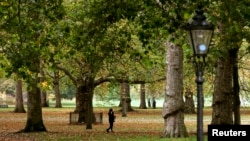 FILE - People walk Green Park during autumn, central London.
