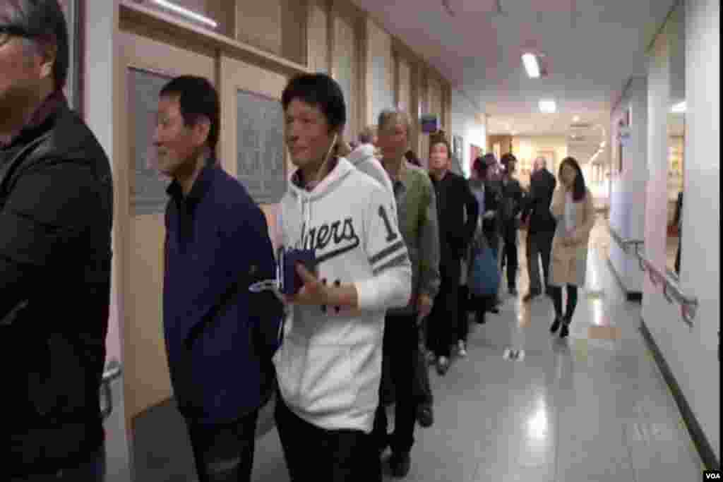 Voters wait in line to enter the polling area in South Korea.