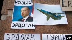 Posters showing a portrait of Turkish President Recep Tayyip Erdogan and reading "Wanted," "Erdogan, Turkey," are left after a protest at the Turkish Embassy in Moscow, Nov. 25, 2015. 