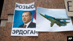 A poster displaying a portrait of Turkish President Recep Tayyip Erdogan and reading "Wanted," is left after a protest at the Turkish Embassy in Moscow, Nov. 25, 2015, following Turkey's downing of a Russian warplane.