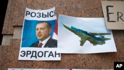 俄羅斯人在土耳其駐莫斯科大使館外示威後留下的俄羅斯戰機圖片和土耳其總統埃爾多安像，土耳其總統像上寫著“通緝”（2015年11月25日）