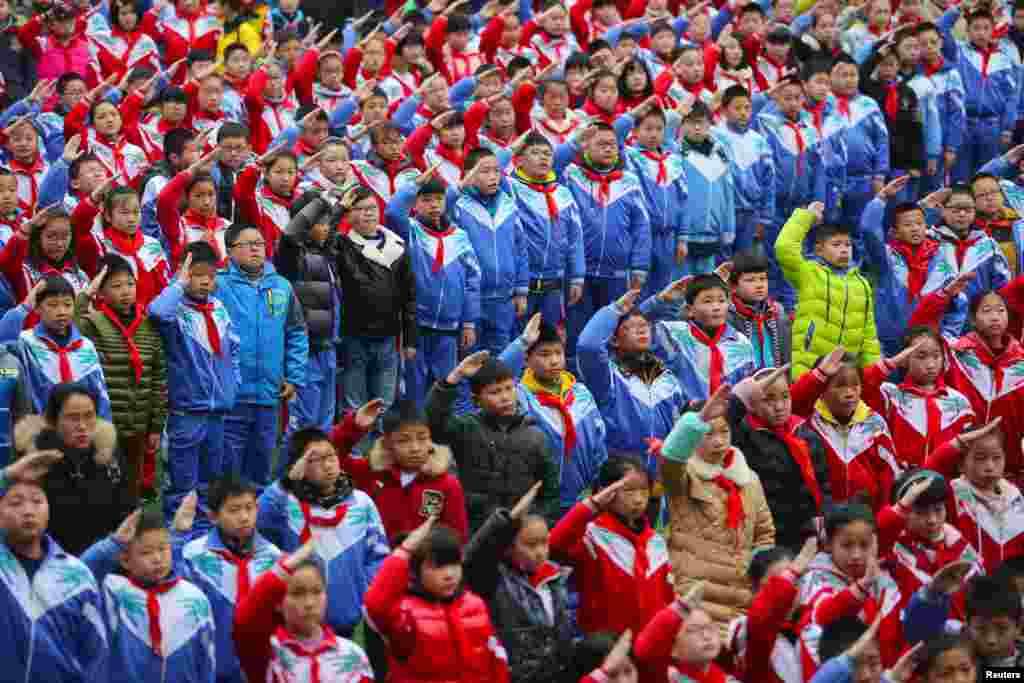 Schoolchildren salute during a flag-raising ceremony on the first day of the new semester in Jiujiang, Jiangxi Province, China.