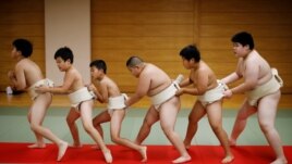 Kyuta Kumagai, 10, warms up with other boys before training, at Komatsuryu sumo club in Tokyo, Japan, August 23, 2020. 