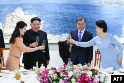 North Korea's leader Kim Jong Un (2nd L) and his wife Ri Sol Ju (L) toast with South Korea's President Moon Jae-in (2nd R) and his wife Kim Jung-sook (R) during the official dinner at the end of their historic summit at the truce village of Panmunjom