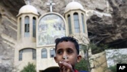 An Egyptian Christian boy holds a cross pendant outside a Coptic church in Cairo. Egyptian security forces began throwing up a cordon of steel as Coptic Christians prepared to mark Christmas after a New Year's Day church bombing killed 21 people in Alexan